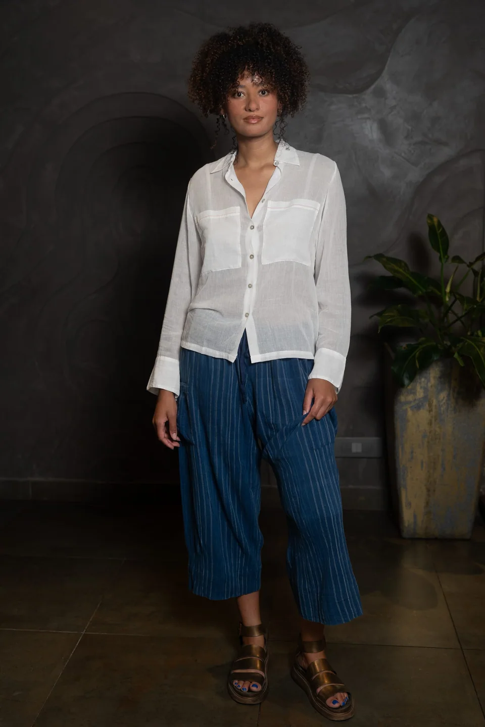White cotton muslin shirt worn over navy striped trousers and sandals